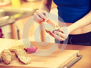 Woman preparing healthy breakfast making sandwich