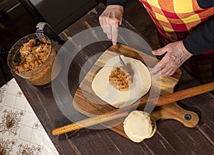 Woman preparing homemade pies with mincemeat filling on the kitchen table