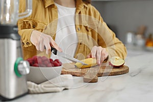 Woman preparing ingredients for tasty smoothie at white marble table in kitchen, closeup