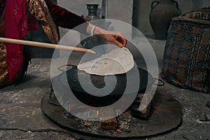 Woman preparing or making borek or bread dough on fire