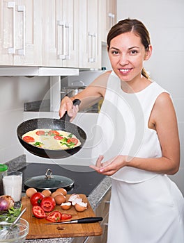 Woman preparing omelet in pan