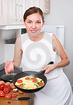 Woman preparing omelet in pan
