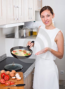woman preparing omelet in pan