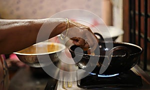 Woman preparing an onion bhajji snack in her kitchen photo