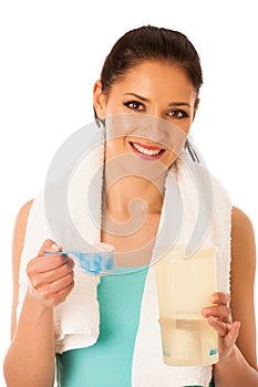 Woman preparing protein shake after fitness workout in gym isolated over white background