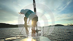 Woman preparing ropes on bow of sailboat on Adriatic sea in Croatia