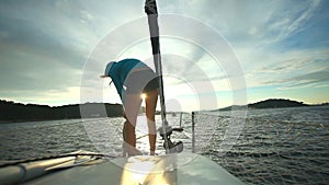 Woman preparing ropes on bow of sailboat on Adriatic sea in Croatia