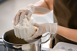 Woman preparing tasty cheese in kitchen, closeup