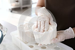 Woman preparing tasty cheese in kitchen, closeup