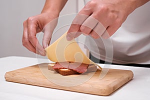 woman preparing toast with cheese and ham close up