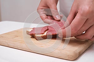 woman preparing toast with ham close up