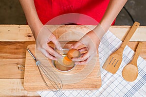 Woman prepeared eggs for cooking on wooden table
