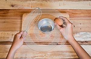 Woman prepeared eggs for cooking on wooden table