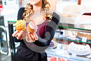 Woman presenting cupcakes of confectionery