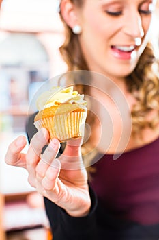 Woman presenting cupcakes of confectionery