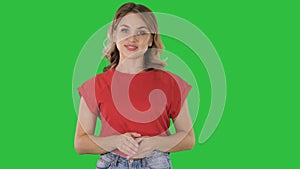 Woman presenting product with her hand showing to side on a Green Screen, Chroma Key.
