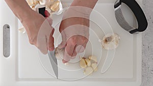 A woman presses fresh garlic using a garlic press tool