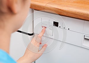 Woman Pressing Button Of Dishwasher