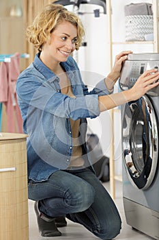 Woman pressing button to start washing machine