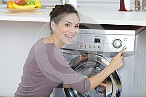 woman pressing button to start washing machine