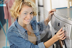 woman pressing button washing machine for laundry