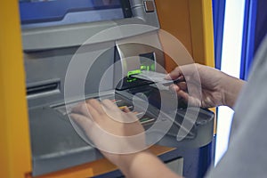 Woman pressing cash card at ATM cabinet.This image is soft Focus