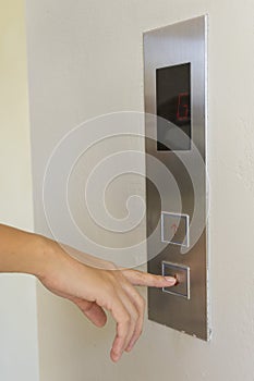 Woman pressing elevator button.