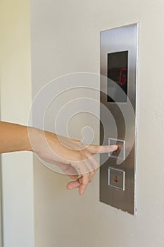 Woman pressing elevator button.