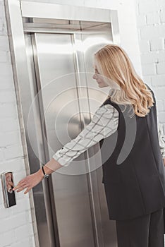 Woman pressing elevator button