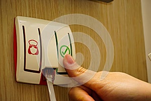 Woman pressing an emergency call button at the hospital room
