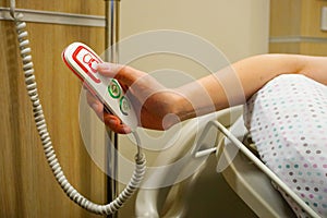 Woman pressing an emergency call button at the hospital room