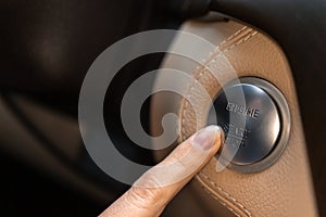 Woman pressing engine start and stop button in luxury sport car close-up view