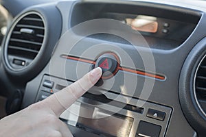 Woman pressing hazard lights button