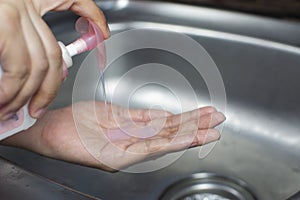 Woman pressing liquid soap antibacterial on her hand for washing hand to against infection coronavirus,Covid-19.
