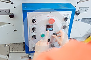 Woman pressing start button on label printing machine