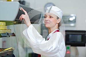 woman pressing switch on food cabinet