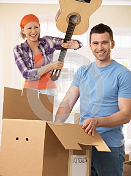 Woman pretending to attack man with guitar