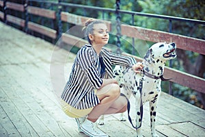 Woman pretty girl on the bridge holding her dog who is barking to strangers