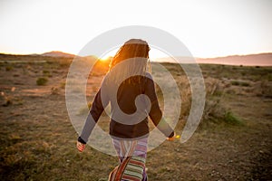 Woman in a pristine landscape during a beautiful blazing sunset