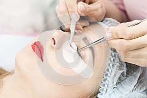 Woman on the procedure for eyelash extensions,