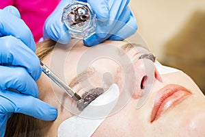 Woman on the procedure for eyelash extensions,