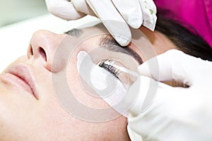 Woman on the procedure for eyelash extensions,