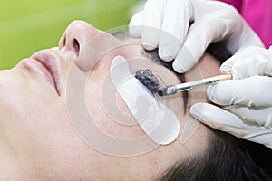 Woman on the procedure for eyelash extensions,