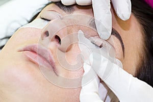 Woman on the procedure for eyelash extensions,