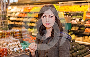 Woman in the produce section of a grocery store.