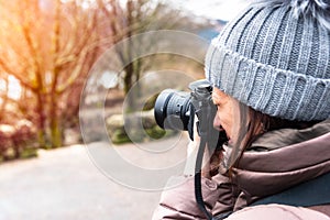 Woman professional photographer taking photos outdoor in winter