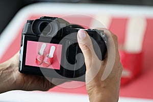 Woman professional photographer taking picture of red trendy shoes