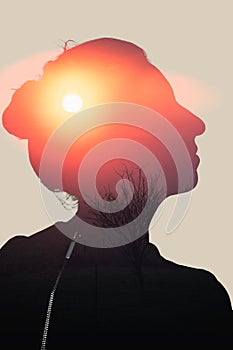 Woman in profile looking upwards on a setting sun background, double exposure energy, relaxation, wellbeing