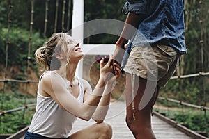 Woman proposing to her happy girlfriend outdoors love and marriage concept