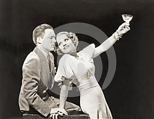 Woman proposing a toast to hesitant man